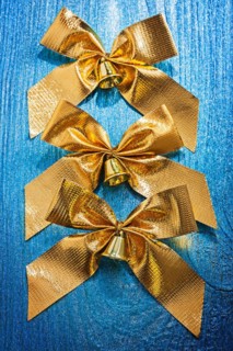 Composition of golden arches with bells painted on old blue colour wooden board
