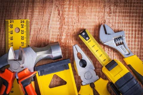 Hand tools spanner tapeline pliers level hammer pliers ruller on vintage wooden board construction concept