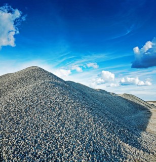 Big pile of grey granite gravel with sky background construction concept