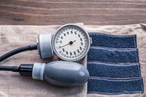 Blood pressure monitor on wooden board Close-up