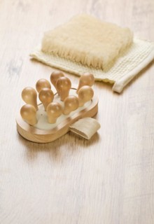 Massager and raffia on a wooden background