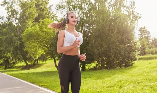 Fitness girl in sportswear runs through the evening sunny park. Healthy lifestyle. Mixed media