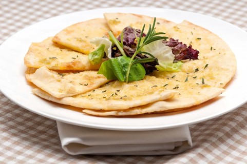 Fresh healthy garlic pita bread pizza with salad on top