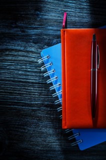 Composition of pocketbooks pen on wooden board