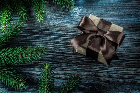 Brown present box pine branches on wooden board
