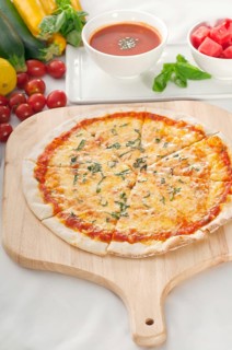 Italian original thin crust pizza Margherita with gazpacho soup and watermelon on side