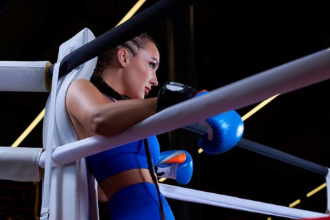 Powerful charged girl stands in the corner of the ring and is ready to explode in the next round. The concept of wrestling and boxing. Mixed media