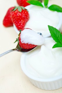 Organic Greek yogurt and strawberry over white rustic wood table