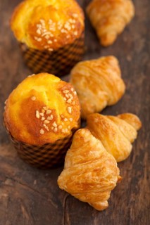 Fresh baked muffin and croissant mignon on old wood table