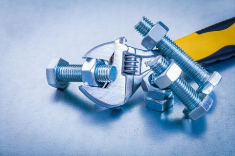 Adjustable tensioner bolt details and screw nuts on metallic background construction concept