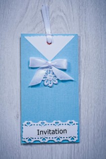 Blue invitation envelope on a grey background