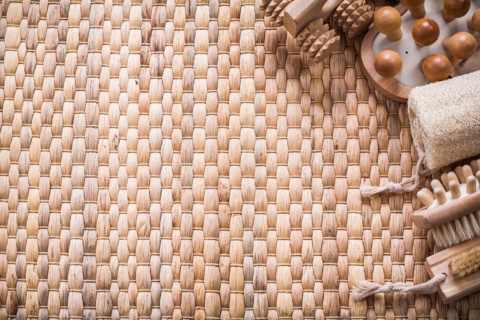 Copy space image of brush wooden massagers and loofah on wicker mat healthcare concept