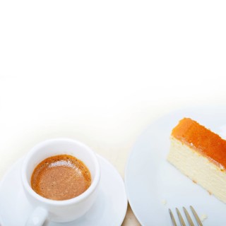 Italian espresso coffee and cheese cake over white wood table