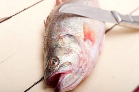 Fresh whole raw fish on a wooden table ready to cook