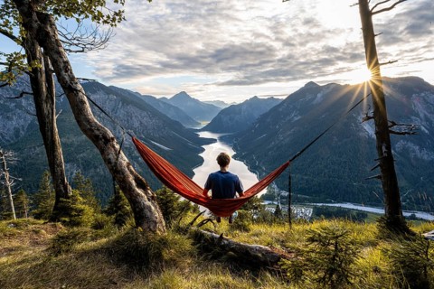 Young man sitting in an orange hammock