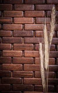 Golden wheat and rye ears on wooden mat vertical version