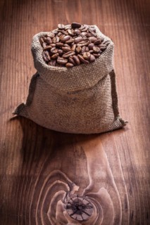 Bag of coffee beans on an old wooden board