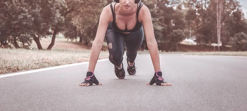 Image of a girl in headphones who stands in a lower position before starting to run. The concept of a healthy lifestyle. Mixed media