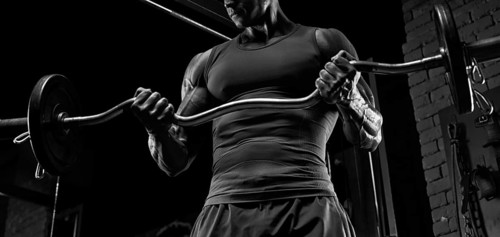 No name strong athletic man pumping up muscles
