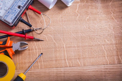 Organised copyspace electrical tools multimeter tester nippers screwdriver roll insulating tape On Wooden Board