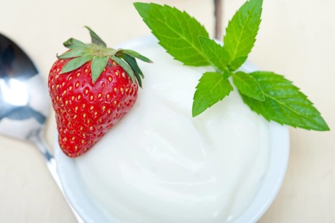 Organic Greek yogurt and strawberry over white rustic wood table