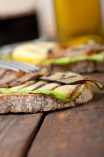 Grilled vegetables on rustic bread over wood table