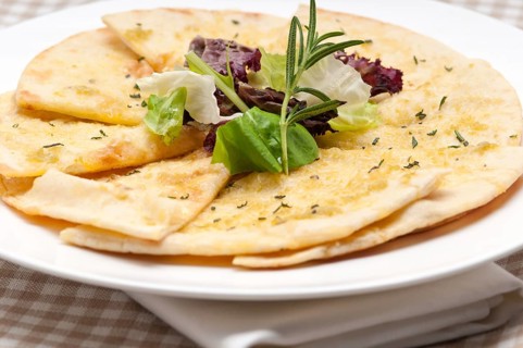 Fresh healthy garlic pita bread pizza with salad on top
