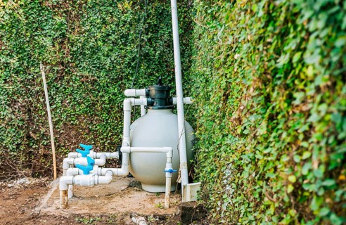 Home swimming pool filter and treatment plant installed. Pool pump with sand filter installed. Pool purification and maintenance system