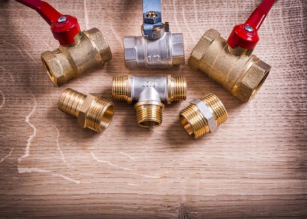 Group of pipe connectors and fittings on wooden board