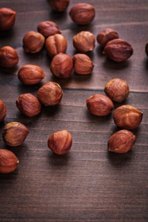 Hazelnut kernels on vintage wooden board Food and drink concept