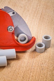 Pipe cutter with pipes on wooden plate