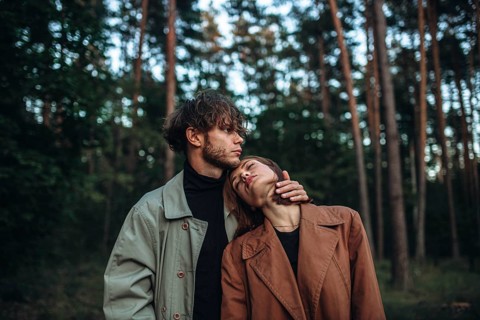 Romantic couple of lovers on a date in the park in cold weather. Fashionable couple in coat