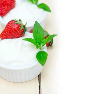 Organic Greek yogurt and strawberry over white rustic wood table