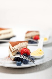 Classic Italian tiramisu dessert with berries and custartd pastry cream on side