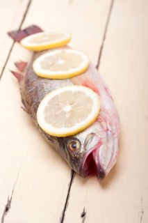 Fresh whole raw fish on a wooden table ready to cook