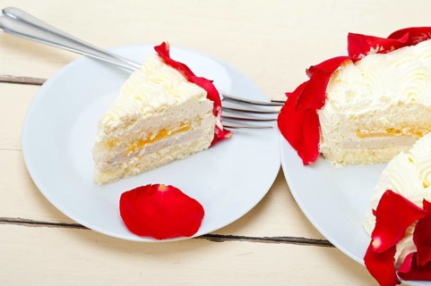 Whipped cream mango cake with red rose petals