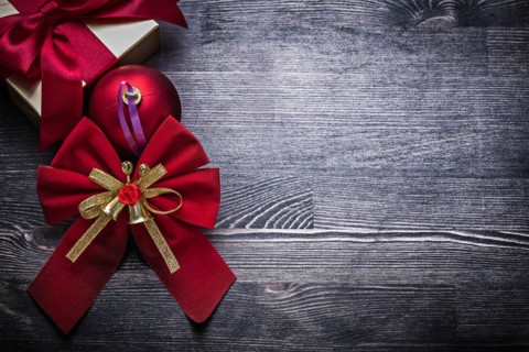 Christmas bauble bow wrapped gift box on wooden board