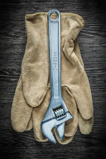 Adjustable spanner safety gloves on wooden board