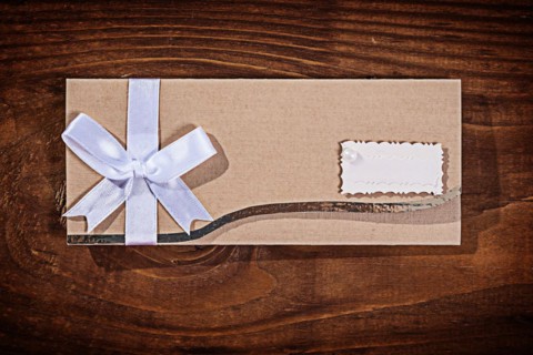 Light brown wedding invitation envelope on an old wooden board