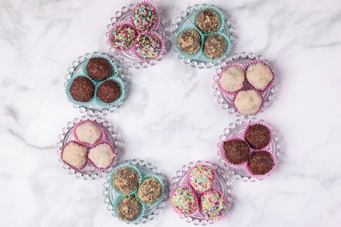 Light and dark rum balls arranged in a circle on glass plates