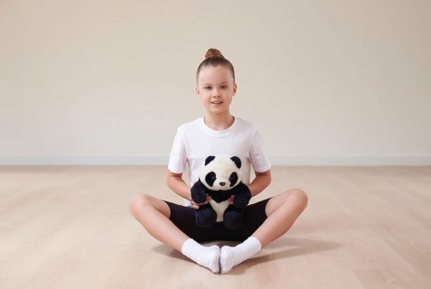 Cute girl child posing in the studio with a soft toy in a light studio. The concept of education