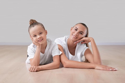 Beautiful female teacher poses with a little girl in a gymnastics class. The concept of education