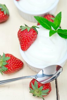 Organic Greek yogurt and strawberry over white rustic wood table