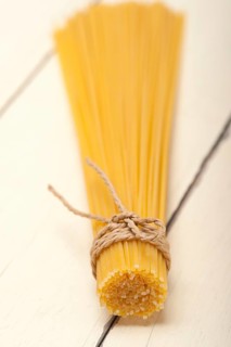 Italian pasta spaghetti tied with a rope on a rustic table