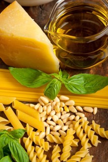 Italian basil pesto ingredients and raw pasta over old wood macro