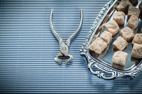 Brown sugar pliers tray on striped background