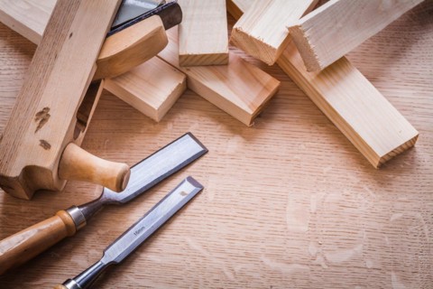 Chisel Woodworker Plane and planks on wooden board