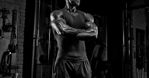 No name strong athletic man pumping up muscles