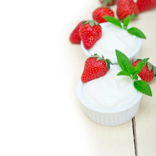 Organic Greek yogurt and strawberry over white rustic wood table