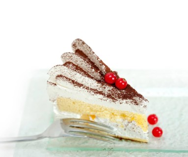 Fresh ribes and whipped cream dessert cake slice with cocoa powder on top
